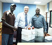 Fina banku2019s managing director Steve Caley (C) hands over cricket balls and a First-Aid kit to Rwanda Cricket Association (RCA)u2019s Robert Mugisha (L). On the right is RCA president Charles Haba
