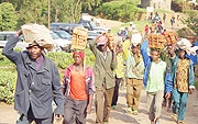 Residents carry bricks for the construction of classrooms during umuganda.