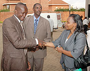 Minister Joseph Habineza (L) shakes hands with Christine Tuyisenge as the commission Executive Secretary Jean de Dieu Mucyo looks on. (Photo/ J. Mbanda)