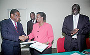 Foreign Affairs Minister Rosemary Museminali (C) and Kenyan Attorney General Amos Wako shake hands after signing as justice Minister Tharcise Karugarama looks on. (Photo J. Mbanda)