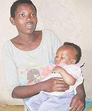 Vestine Mukamana carries her 9 month old baby at her home (Photo: S. Nkurunziza)