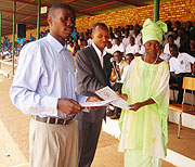 A Primary school teacher being awarded a certificate of merit in recognition of her dedication to work. (Photo/ P. Ntambara)