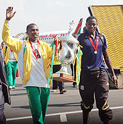 Bakame (R) showing off the Cecafa trophy at Kigali International Airport. The goal custodian has joined APR leaving a huge vaccum at Atraco