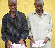 Irisanga Amos and Alphonse Nikwigize with the counterfeit currency. (Photo/ B. Mukombozi)
