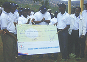 (R)RECO boss Yves Muyange handing over a Rwf 20M to Education Minister Charles Muligande (L). (Photo/F. Goodman)