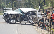 Residents view the  wreckage of the vehicle in which Ruzigana was travelling.(Photo D. Sabiiti)