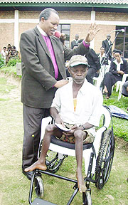 Archbishop Kolini Emmanuel prays for one of the beneficiaries shortly after receiving his wheelchair (Photo: S. Nkurunziza)