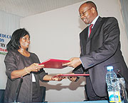 Finance Minister, James Musoni, and World Bank Country Manager, Mimi Ladipo, exchanging documents after signing a $35m grant to support the Education Sector on Thursday.(Photo/ J Mbanda)
