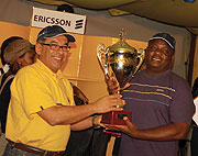 MTN-Rwanda CEO Khaled Mikkawi hands over the winneru2019s trophy to Davis Kashaka (R).