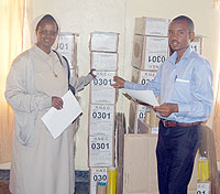 Karongi District Director of Education, Michel Mulindankiko(right), hands over Examinations to one of the school directors yesterday (Photo/ S. Nkunziza)