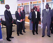 Francois Kanimba (extreme right) and Ephraim Kabaija (extreme left) listen to explanations from a bank official during the official launch of the UOB in Eastern Province. (Photo/ S. Rwembeho)