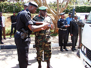 Commissioner General of Police, Emmanuel Gasana (L), sharing ideas with a coleague during the launch of the Road Safety Week
