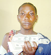 ALONE AND FRIGHTENED; Anastasie Nyirankuriza with part of the money that was discovered from her parentsu2019 home. (Photo/ B. Asiimwe)