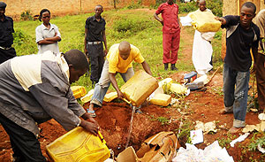 Pouring the illicit beer. (Photo/ S. Rwembeho)