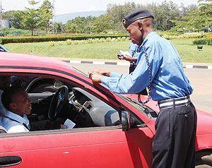  A Police officer puts a sticker on a car during the Road safety week.
