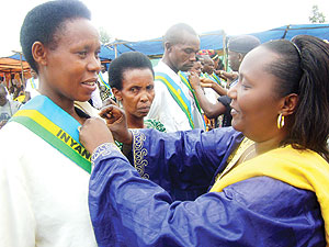 Domitile Mukantaganzwa decorates a judge with a medal. (Photo / S. Rwembeho)
