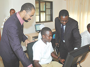Al Bashir Project Manager Haitham B Yousif (L) and MINEDUCu2019s Richard Niyonkuru inspect the donated computers yesterday. (Photo/ J. Mbanda)