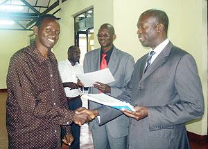 Minister Murekezi hands a certificate to Joshua Mugisha, one of the trained retrenched civil servants. (Photo / D. Sabiiti)
