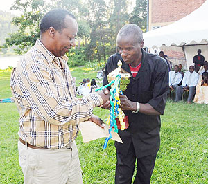 Western Province Governor Celestin Kabahizi hands the trophy to the representative of the best perfoming group from Rutsiro District. (Photo: S. Nkurunziza)