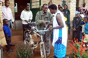 Huye Sector Executive Secretary JB Mutabaruka hands over a bicyle to one of the beneficiaries. (Photo: JB Nteringanya)