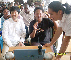 A student assisted by Japanese specialist communicates in real time  with a fish farmer in Japan. (Photo: S. Rwembeho)
