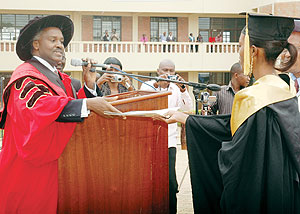 CONGLATULATIONS: Education Minister Charles Murigande hands the best student, Nibaruta Mahoro, a cetificate of excellence at the graduation ceremony yesterday (photo. F. Goodman)
