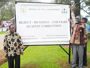 Governor Fidu00e8le Ndayisaba (L) and Tito Rutaremara after unveiling an anti-corruption poster in Huye yesterday. (Photo: P. Ntambara)