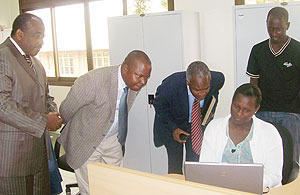 Education Minister Dr Charles Murigande and WDA Director General Dr Jean Damascene Gatabazi look on as Lucie Kabatesi takes them through the Rwanda LMIS website (courtesy Photo)