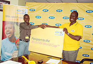 WINNERu2019S SMILE; Newtimesu2019s Bonnie Mugabe receives the passport ticket to watch the 2010 World Cup from MTNu2019s Chief Operations officer Andrew Rugege yesterday. 