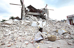 A child sitting in the ruins of her home.