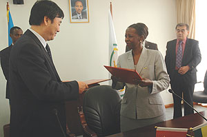 Zhai Jun (L) and Mushikiwabo exchange documents(File Photo)
