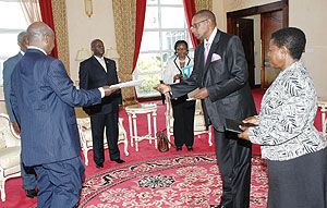 Rwandau2019s new High Commissioner to Uganda, Frank Mugambage (R), presenting his credentials to President Yoweri Museveni on Tuesday.