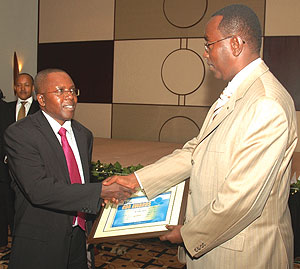 Prime Minister Bernard Makuza presents a certificate to CMACu2019s Robert Mathu at the RDB awards ceremony on Friday. (Photo/ F. Goodman)