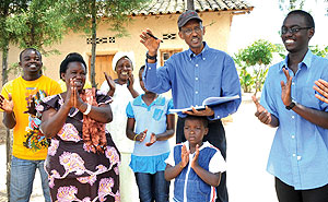 President Kagame signs an autograph for Alphonsine Mwubahimana and her family after visiting her dairy project