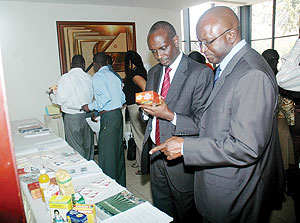 Health Minister Dr Richard Sezibera (L) and the U.S Agriculture attachu00e9 in Nairobi Diaby Souleymane examine Soybean flour on display at the conference. (Photo J Mbanda)