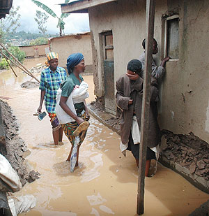 A Woman weeps after losing all her property as neighbors ponder what do next in their flooded compounds yesterday. (Photo J Mbanda)
