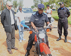 Chief Sup. Jimmy Hodari tests one of the motorcycles as Police Chief Emmanuel Gasana (R) and BTCu2019s Jean Yves Saliez look on yesterday. (Photo/ J. Mbanda)