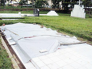 The grave is now covered by plastic tents after it collapsed. (Photo: S. Rwembeho)