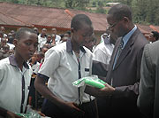 State for education, Dr. Mathias Harebamungu, hands over a laptop to one of the beneficiaries at SOS Primary School yesterday (Photo; F. Goodma