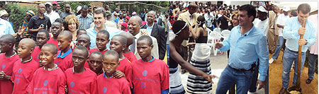 L-R : Some of the Kiziba children who will benefit from the Multi- purpose Education Centre ; On the dance floor enjoying Kinyarwanda music ; Laporta grinds food in a local pounding mortar (Photos by S. Nkurunziza) 