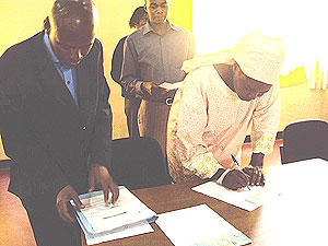 Families of victims sign for their compensation. (Photo: B. Mukombozi)