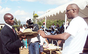 Patrick Makuza, the club president receives one of the many gifts from Ernest Mukunzi, the head of the orphanage. (Photo: D. Sabiiti)