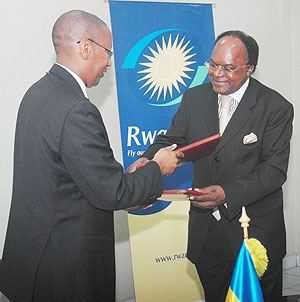 Finance and Economic Planning Minister, John Rwangombwa, exchanges documents with Dr Michael Gondwe, PTAu2019s president. (Photo/ Goodman)