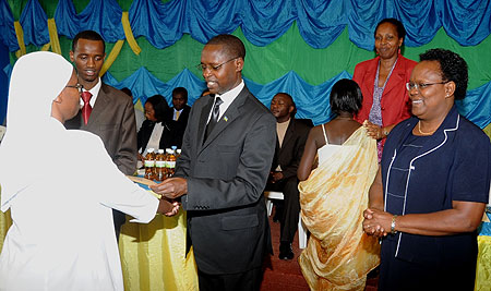 Minister Mathias  Harebamungu handing over the cheque to the administrator of one of the winning schools yesterday ( Phot F. Goodman )