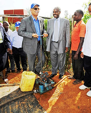 Ambassador Abderrahim Ould Hadrami trying a water pump at Murama school, while Dr. Charles Murigande looks on. (Courtesy photo)