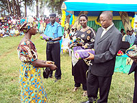 Dr. Lu00e9onard Kagabo hands over a reward to one of the Mothers. On his right Vice Mayor Anita Mutesi looks on. (Photo: S. Rwebeho)