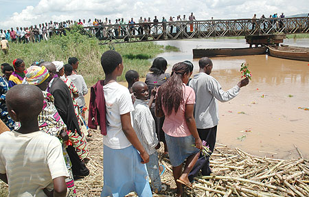 Residents of Kanzenze in Bugesera District throw flowers in Akagera river on Wednesday to honour their beloved ones who were dumped in the river during the 1994 Genocide against theTutsi. 