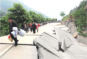 A damaged road with people migrating in search for safety