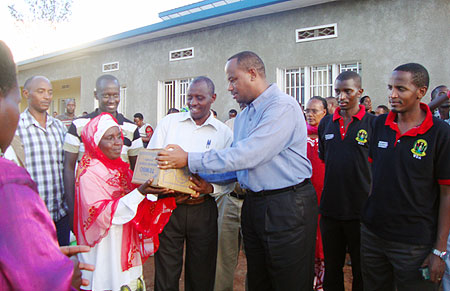 WDA Director General, Albert Nsengiyunva, hands over some of the  donations to one of the widows. (Courtesy photo)