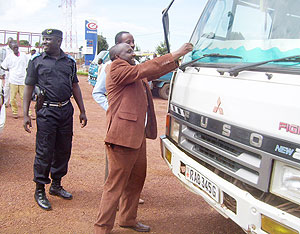 Gicumbi district Mayor, Bonane Nyangezi placing  a road safety sticker on a vehicle in the company of Supt.Gashiramanga. (Photo: A. Gahene)